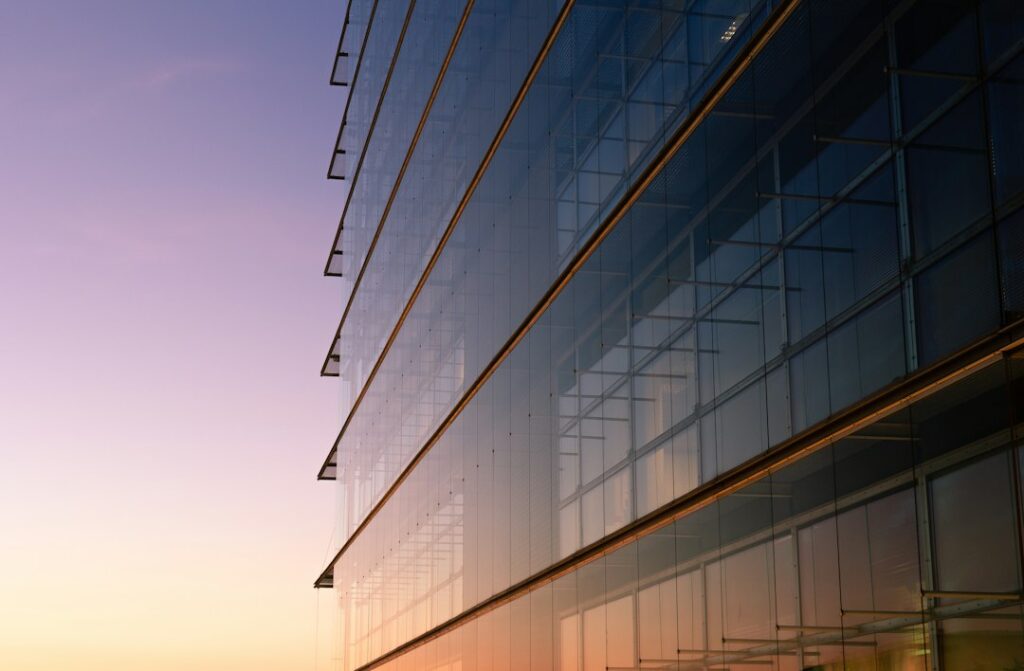 Modern glass-fronted office building; illustrative image, not Persistent Systems' Hyderabad facility