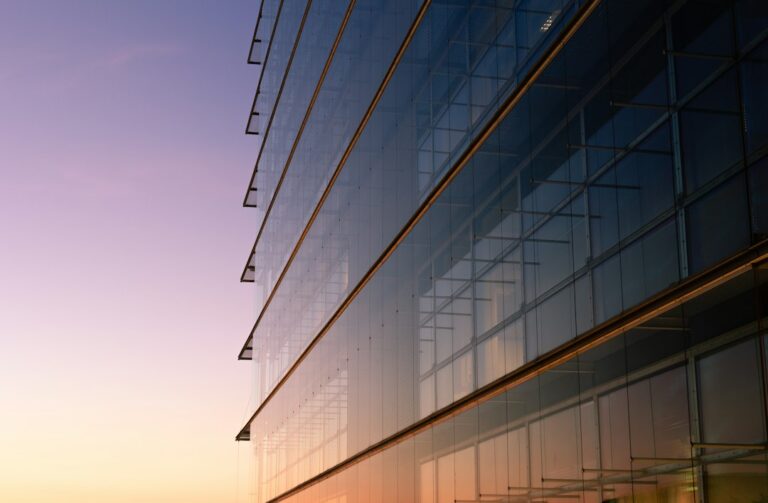Modern glass-fronted office building; illustrative image, not Persistent Systems' Hyderabad facility