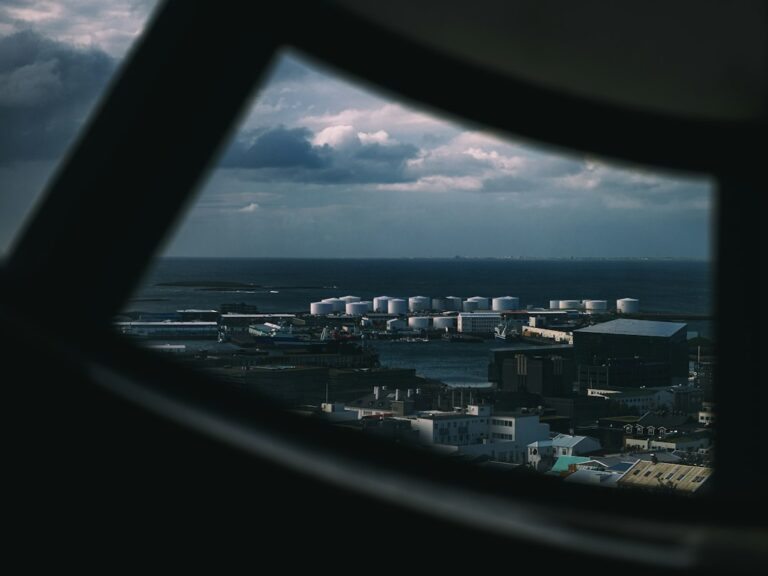 Oil storage tanks and industrial port infrastructure, illustrating global crude oil supply and shipping