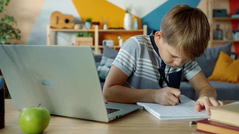 A student using a laptop and notebook while studying, illustrating how to verify information provided by AI