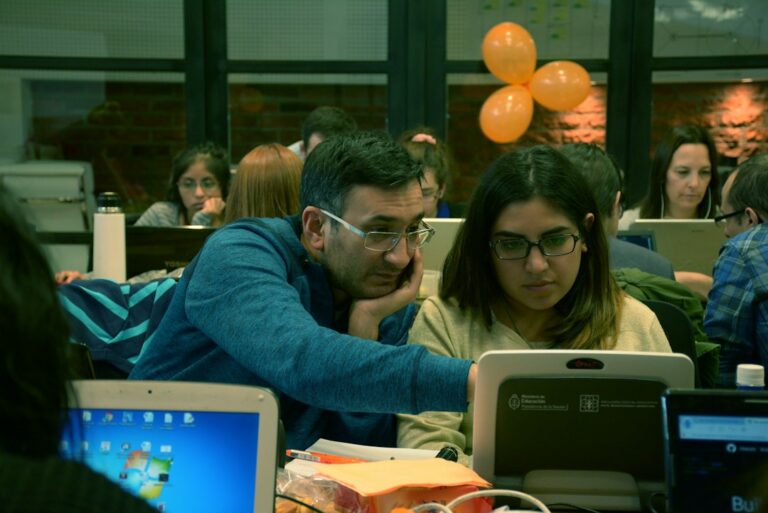 University students working together with laptops on technology research