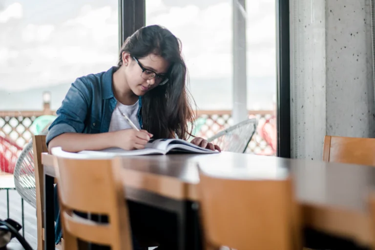 A student writing and studying at a desk