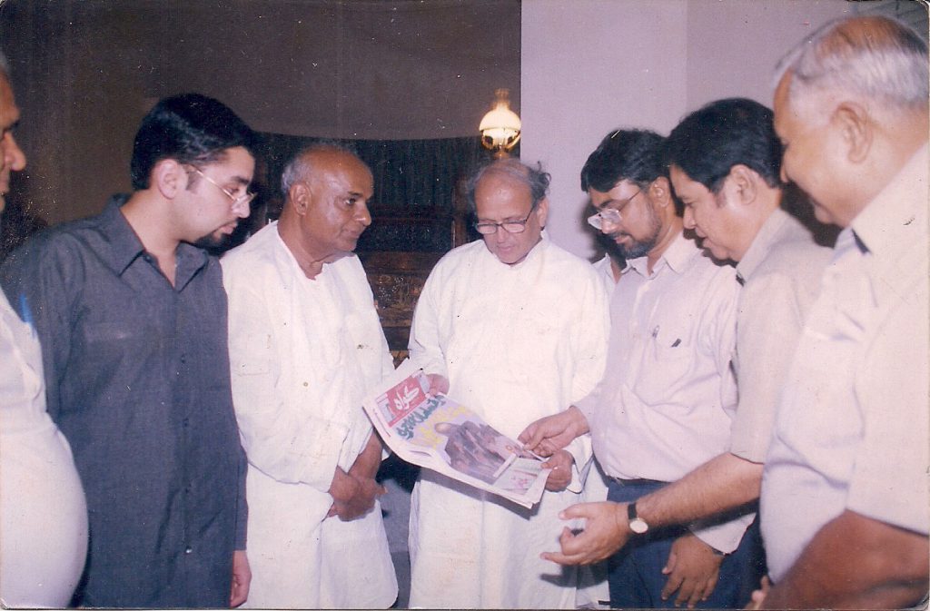 In this picture, former Prime Ministers of India Mr. SB VP Singh and Mr. Deva Gowda glance through a copy of GAWAH. Chief Editor Syed Fazil Hussain Parvez is also seen.